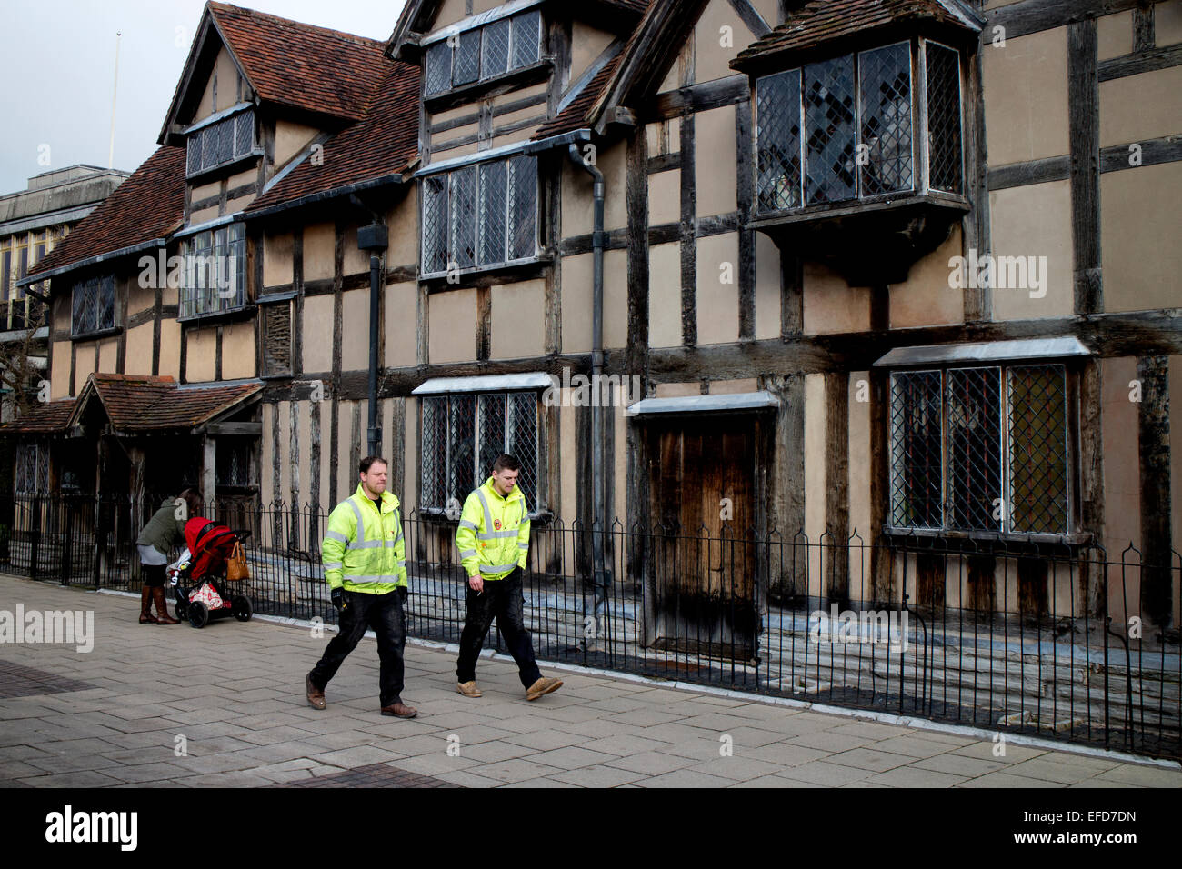 Men wearing hi-vis jackets walking past William Shakespeare`s Birthplace, Stratford-upon-Avon, UK Stock Photo